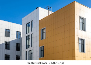 Fragment of a complex of buildings of variable storeys with windows of different sizes for blogs, sites on the construction, architectural theme. A ventilated facade made of composite panels of differ