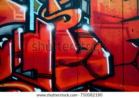 A fragment of detailed graffiti of a drawing made with aerosol paints on a wall of concrete tiles. Background image of street art in warm red color tones