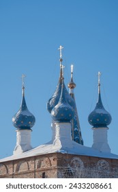 a fragment of the exterior of an Orthodox church with stucco and gilded domes and crosses