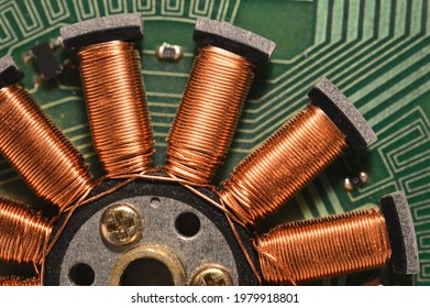 Fragment of floppy drive motor with copper wire coils closeup