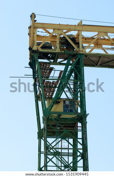 a fragment of a gantry crane with a crane\
operator\'s cabin against the\
sky