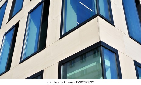 A fragment of the glass and sandstone facade of a modern office building. Wide abstract fragment of modern building facade. View of modern glass and stone facade.