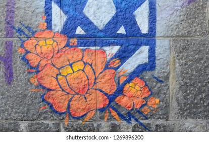 Fragment of graffiti drawings. The old wall decorated with paint stains in the style of street art culture. Orange flower - Powered by Shutterstock