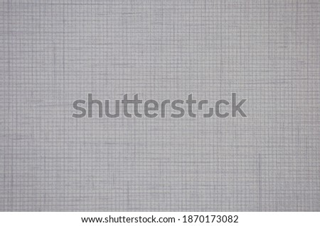 A fragment of gray fabric with a characteristic pattern of weaving in a cage close-up. Background, texture.