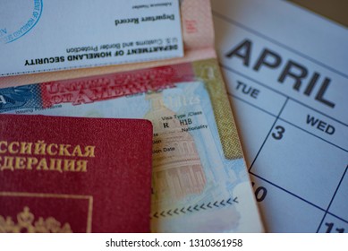 Fragment Of H1B Visa (for Specialty Workers) Stamp In Passport Next To  Blurred April Calendar And Red Russian Passport On Background. H1B Visa Program Deadline Concept. Close Up View. 