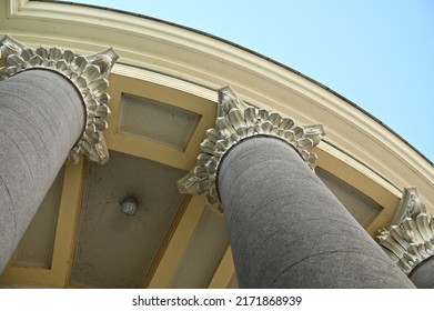 A Fragment Of A Historic Building With A Curved Parapet And Round Columns