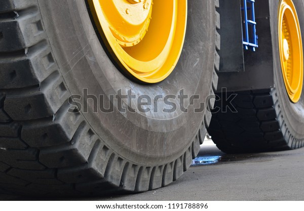 \
A fragment of a huge wheel and\
tire of construction equipment. Career\
  dump\
truck.
