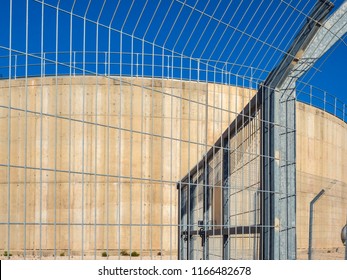 A Fragment Of The Industrial Building With A Metal Modern Fencing In The Daytime On The Background Of The Blue Sky.