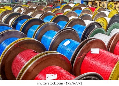 Fragment inside a modern plant producing power electric cable and optical fiber. Interior of modern production line. Finished goods on container cable reels for transportation and sale of consumer 
