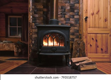 Fragment of the interior of a country house. The iron furnace is heated. There is wood near the stove. It's dark outside the window. - Shutterstock ID 793518757