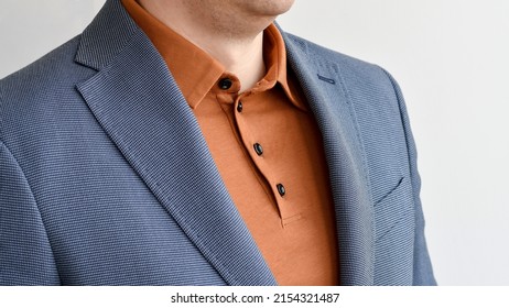 Fragment of light blue blazer combined with fashionable beige polo. Selective focus.