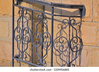 A Fragment Of A Metal Fence On A Stone Background Close-up