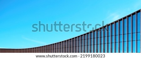 Fragment of the mirror wall of the building against the blue sky.
office building covered with glass. Place for an inscription, advertising. Panorama.