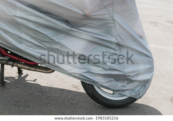 A fragment of a motorcycle in the parking
lot, covered with a protective
film