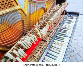 A Fragment Of An Old Broken Piano With A Missing Wall And Broken Keys. Front View