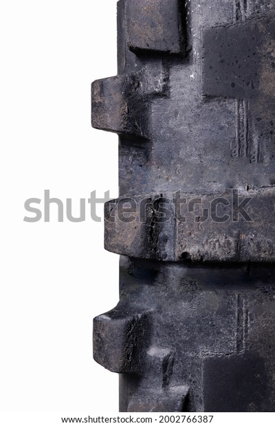 Fragment of an old motorcycle tire.\
Worn tire tread from a cross bike. Isolated\
background.