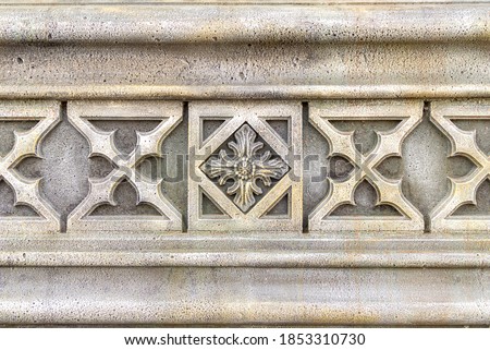fragment of an ornament on a stone, decoration for a stone wall or fence, selective focus