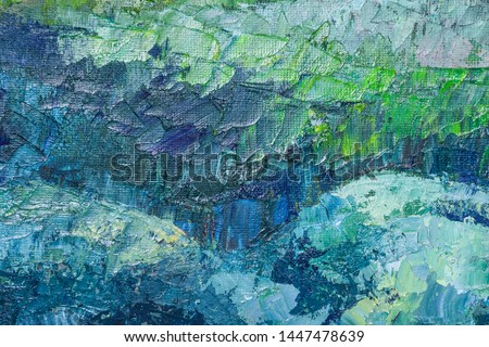 Fragment of pictorial artwork close up. On the canvas, large strokes of blue, green, turquoise and gray paint are applied. Textured painting with a palette knife. Modern art. 