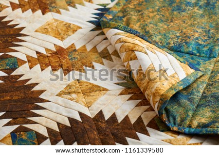 Fragment of quilt stitched from pineapple pattern blocks, traditional patchwork