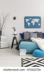 Fragment Of A Spacious But Very Cosy Bedroom With A Bed Full Of Cushions And Fluffy Blankets, And A Pile Of Books In Front Of It