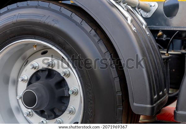 Fragment of a truck wheel
close-up. Clean truck tire. Rubber tire, steel wheel rim and
plastic mudguard