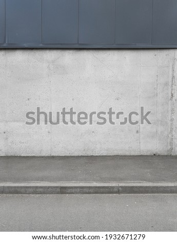 a fragment of an urban concrete wall of a building and an asphalt sidewalk, a building facade, a template or source