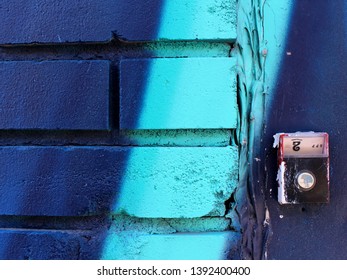 A Fragment Of A Wall Painted In Two Shades Of Blue - Dark And Turquoise - And A Doorbell With Number Of Apartment 2 In The Old City, Retro Style.