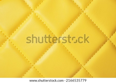 Fragment of a yellow quilted bag, close up
