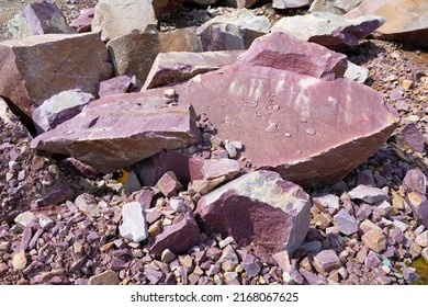 Fragments of crimson quartzite close-up on a sunny day. Karelia
