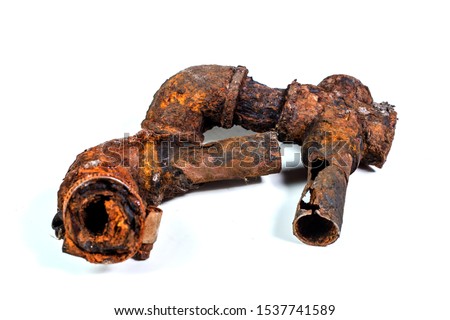 Fragments of old cast-iron water pipes on white background. After many years of operation corroded metal pipe was destroyed. Rusty steel tube with holes of metallic corrosion. Rusty cast iron, metal