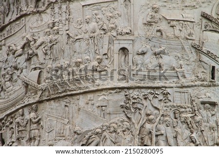 Fragments of  Roman triumphal Trajan's column, ancient monument on streets of Rome, capital of Italy, near the Colosseum and famous Forum. It commemorates Roman emperor's victory in the Dacian Wars.