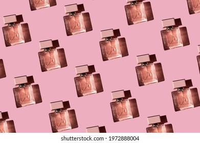 Fragnance Parfume Pattern. Bottles Of Pink Woman Perfume On A Pastel Pink Background, Flat Lay, Top View. Mockup Of Fragrance Perfume. Trendy Sunlight Minimal Concept.

