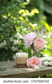 Fragrant Coffee And Luxurious Summer Flowers On The Table In The Garden