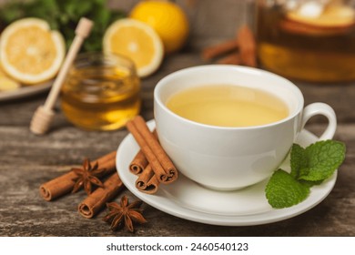 Fragrant hot tea with cinnamon stick and anise on a textured wooden background. A cup of hot tea with honey, lemon, mint and apples. Spicy tea with spices. Immunity tea. Health concept.Copy space. - Powered by Shutterstock