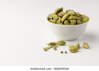 Fragrant oriental spices cardamom pods with seeds in a small white ceramic boul with copy space