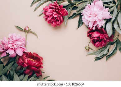 Frame of beautiful peonies on beige background. Mother's day or other holiday background.