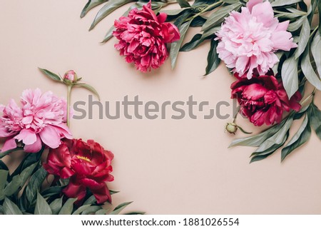 Frame of beautiful peonies on beige background. Mother's day or other holiday background.