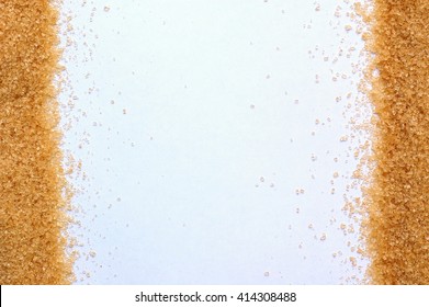 Frame From Brown Cane Sugar On Sides On White Background, Overhead Horizontal View. Raw Healthy Brown Cane Unrefined Sugar.