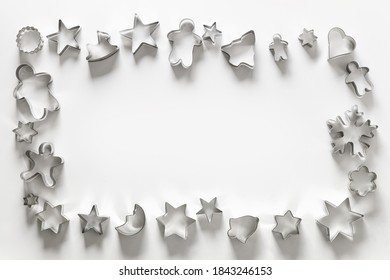 Frame of Christmas-themed cookie cutters on white. Holiday Xmas greeting card. Top view and flat lay.