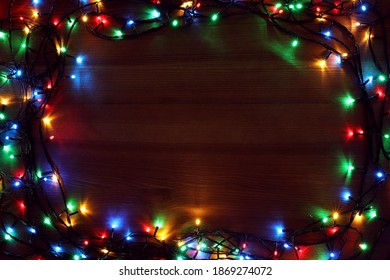 Frame of colorful Christmas lights on wooden table, top view. Space for text - Powered by Shutterstock