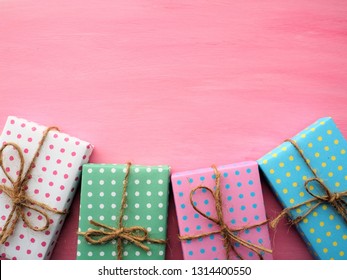 Frame of colorful gift boxes with vintage pink painted wooden background, birthday and Christmas concept