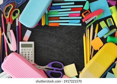 Frame of different stationery on blackboard, flat lay with space for text. Back to school