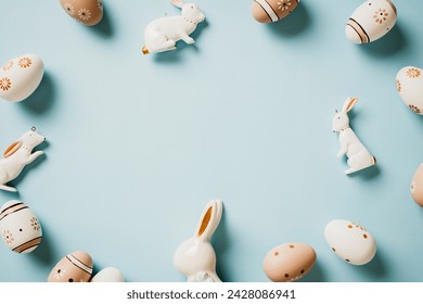 Frame of floral painted Easter eggs with bunny rabbits on pastel blue background. Top view. Flat lay. - Powered by Shutterstock