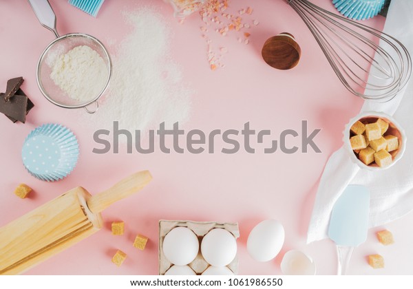 Frame of food ingredients for baking on a gently\
pink pastel background. Cooking flat lay with copy space. Top view.\
Baking concept. Mockup.