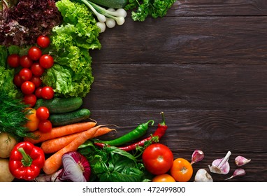 Frame Of Fresh Organic Vegetables On Wood Background. Healthy Natural Food On Rustic Wooden Table With Copy Space. Tomato, Lettuce, Carrot, Garlic, Zucchini And Other Cooking Ingredients Top View