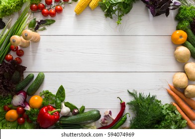 Frame of fresh organic vegetables on white wood background. Healthy natural food on table with copy space. Cooking ingredients top view, mockup for recipe or menu