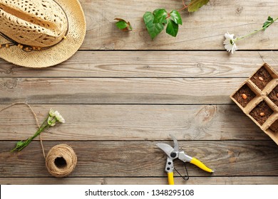 Frame Of Gardening Tools And Flowers On Vintage Wooden Table. Gardening Or Planting Concept. Working In The Spring Garden. Flat Lay, Top View, Overhead.