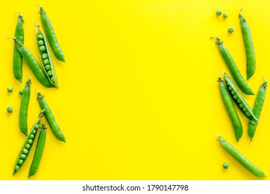 Frame of green pea pods and peas on the kitchen background