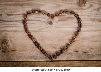 Frame- heart from coffee beans  on  wooden table 