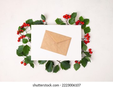 Frame Of Leaves With Autumn Red Hawthorn Berries, Red Berry With White Paper Card Note With Space For Text On A White Background. Top View, Flat Lay